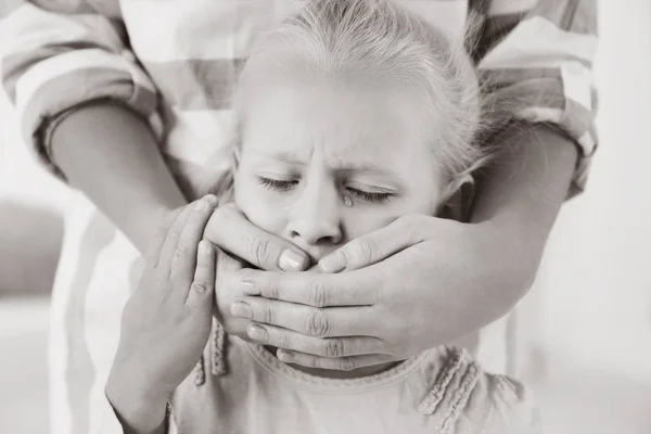 Женщина, прикрывающая рот маленькой девочки — стоковое фото