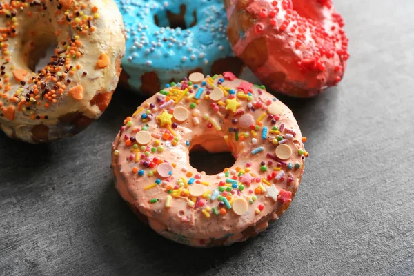 Donuts coloridos gostosos frescos no fundo cinza — Fotografia de Stock