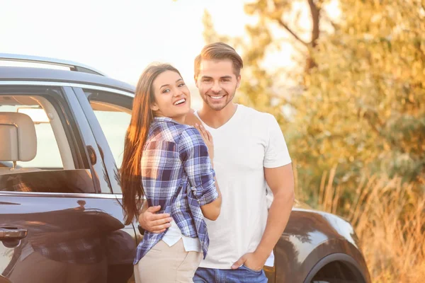 Mooi jong koppel staat in de buurt van auto — Stockfoto