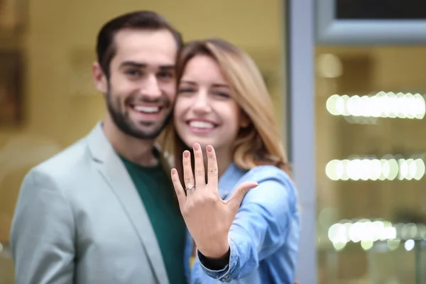 Junger Mann und seine glückliche Verlobte zeigen Verlobungsring — Stockfoto