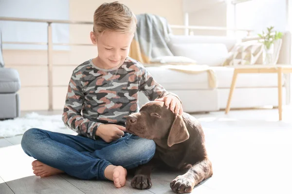 Mignon petit garçon avec chien sur le sol à la maison — Photo