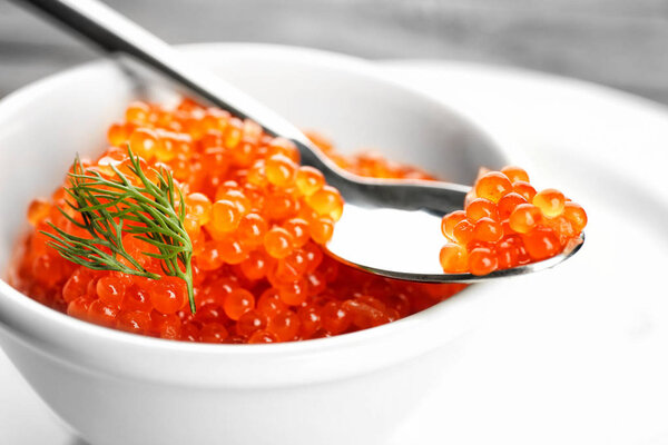 Spoon and bowl with delicious red caviar 