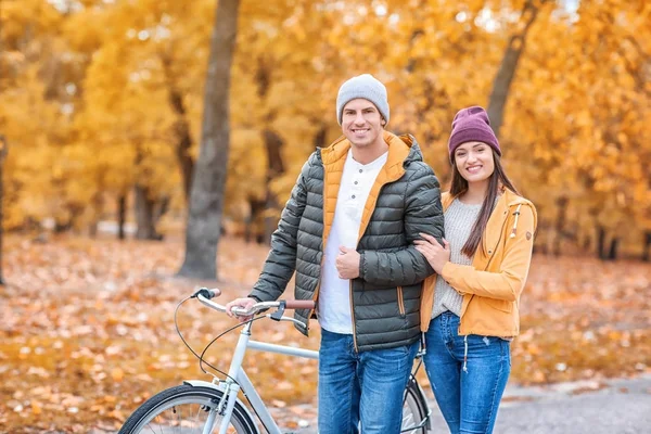 公園で自転車と歩く若いカップル — ストック写真