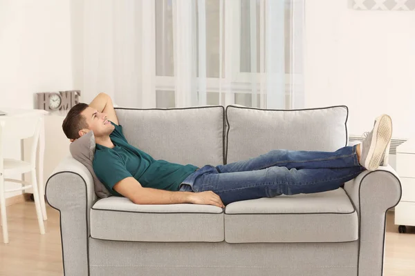 Schöner Mann ruht sich zu Hause auf Sofa aus — Stockfoto