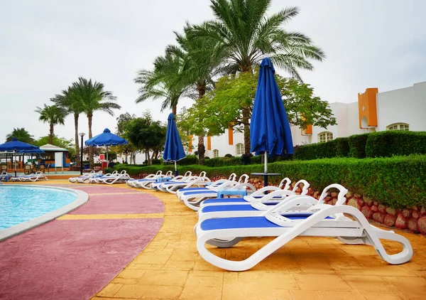 Cómodas tumbonas cerca de la piscina en el resort — Foto de Stock