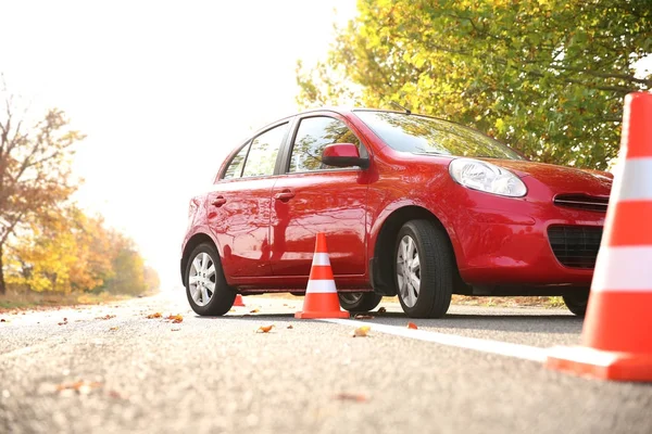 Krásné červené auto a bezpečnostní kužely v autoškole — Stock fotografie