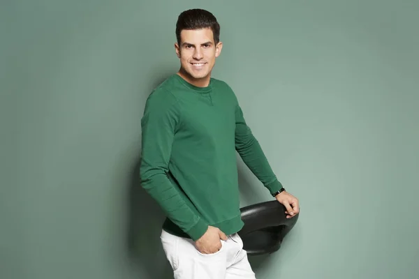 Schöner junger Mann in lässiger Kleidung auf farbigem Hintergrund — Stockfoto