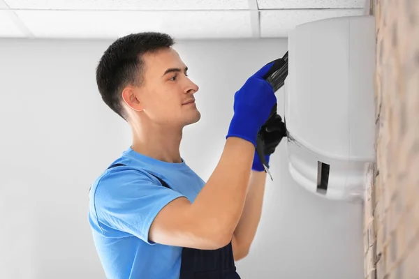 Männlicher Techniker repariert Klimaanlage — Stockfoto