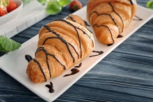 Plate with tasty croissants on table — Stock Photo, Image