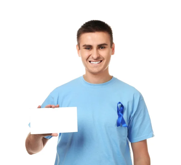 Mladý muž v tričku s modrou stužkou drží prázdné vizitky na bílém pozadí. Koncept povědomí o rakovině prostaty — Stock fotografie