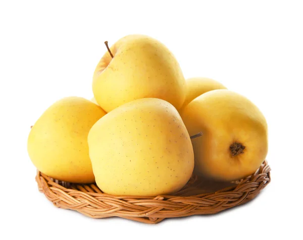 Wicker tallrik med mogna gula äpplen på vit bakgrund — Stockfoto