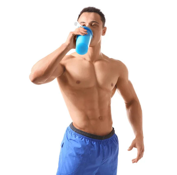 Sportlicher junger Mann trinkt Proteinshake auf weißem Hintergrund — Stockfoto