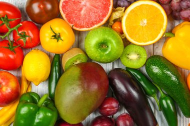 Meyve ve sebze gökkuşağı renkleri, düz ahşap arka plan üzerinde yapılmış yaratıcı kompozisyon yatıyordu