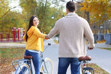 Parkta bisiklete binen genç çift