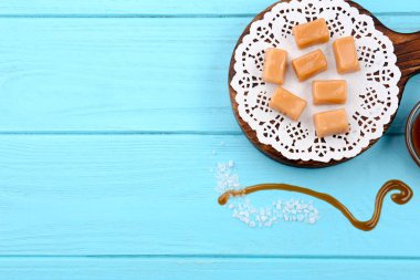 Renk ahşap arka plan üzerinde lezzetli karamelli şeker ile kurulu