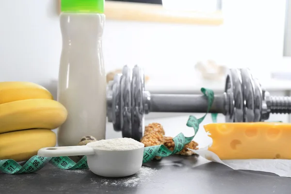 Scoop con polvo de proteína, agitar en botella y productos en la mesa —  Fotos de Stock