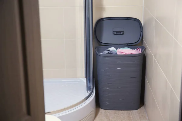 Basket with dirty laundry in bathroom