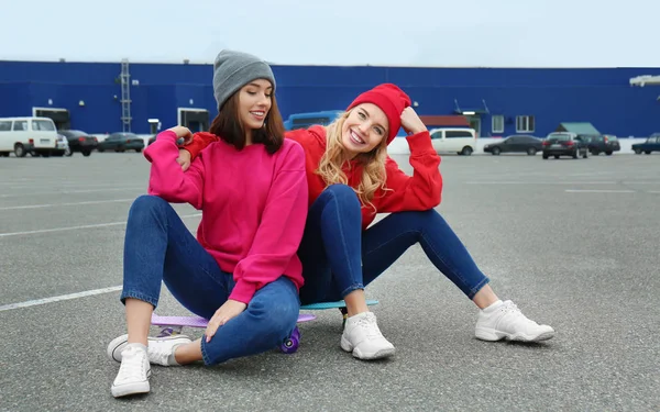 Δύο κορίτσια ευτυχισμένη hipster κάθεται για σκέιτμπορντ σε εξωτερικούς χώρους — Φωτογραφία Αρχείου