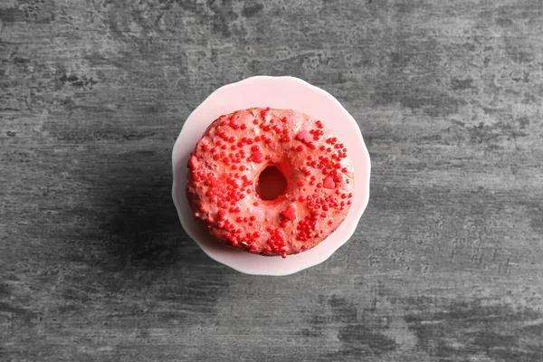 Plate with yummy donut on grey background — Stock Photo, Image