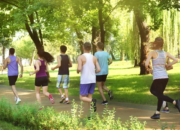 Group of young people running in park