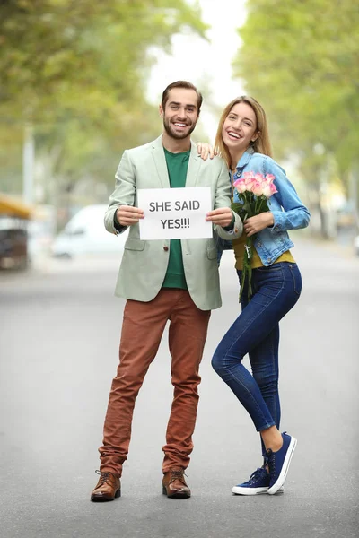 Mladý muž, který držel papír s textem ona řekla ano — Stock fotografie