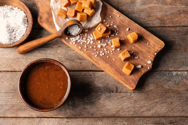 Mangkuk Dengan Saus Karamel Lezat Dan Permen Atas Meja — Stok Foto