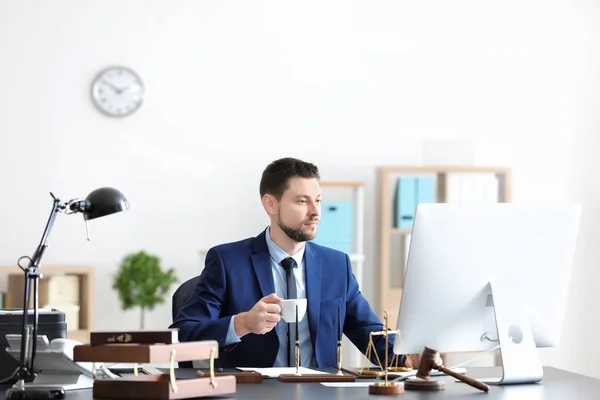 Junger männlicher Notar trinkt Kaffee im Büro — Stockfoto