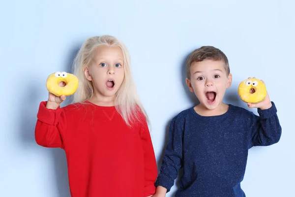 Petits Enfants Avec Des Beignets Doux Sur Fond Couleur — Photo