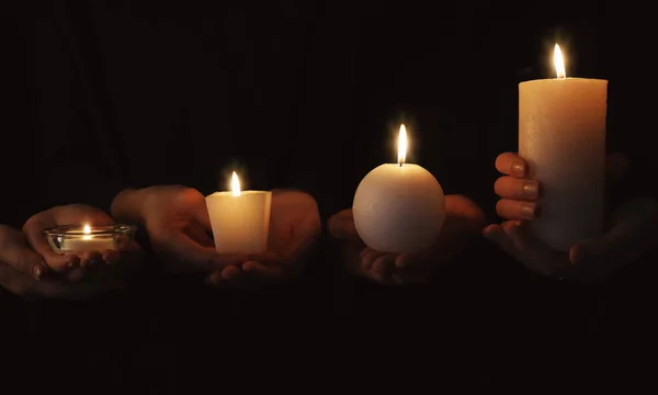 Mani con candele accese — Foto Stock