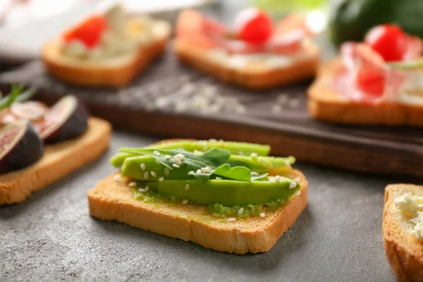 Výborný avokádový toast na stole, closeup — Stock fotografie