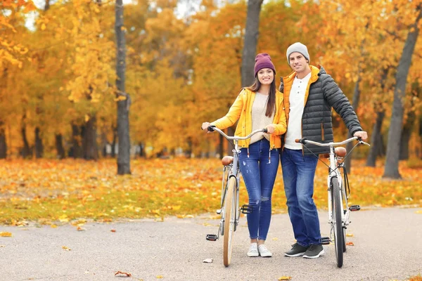 公園で自転車と歩く若いカップル — ストック写真