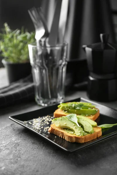 Plate with delicious avocado toasts on table — Stock Photo, Image