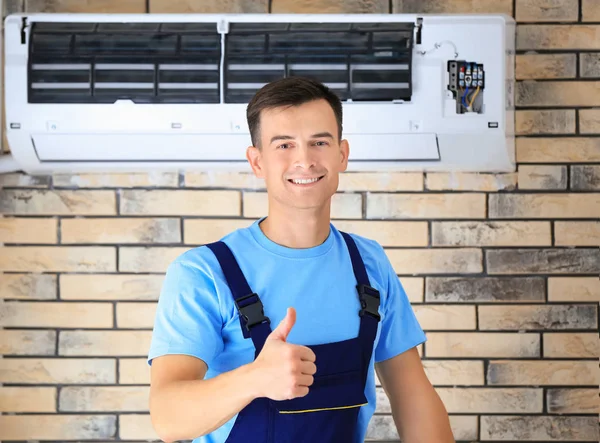 Männlicher Techniker mit reparierter Klimaanlage — Stockfoto