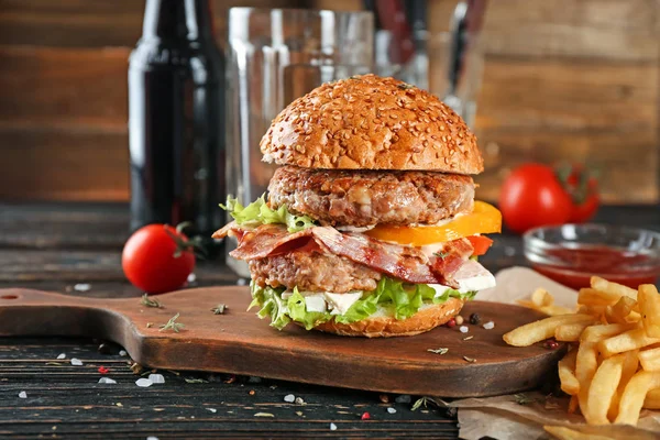 Mesa con sabrosa hamburguesa doble sobre mesa de madera — Foto de Stock