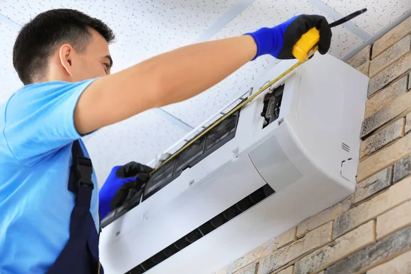 Männlicher Techniker repariert Klimaanlage — Stockfoto