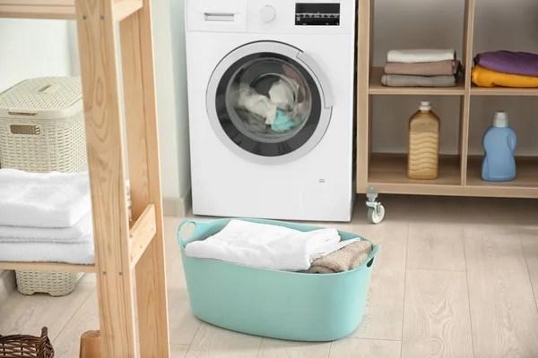 Cesta com lavandaria e máquina de lavar roupa no banheiro — Fotografia de Stock