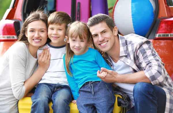 Famille heureuse avec bagages près de la voiture — Photo