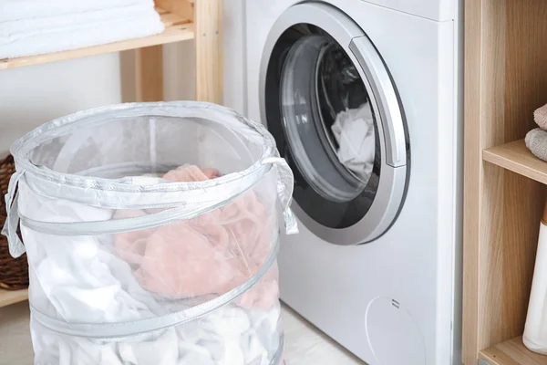 Laundry basket and washing machine indoors — Stock Photo, Image