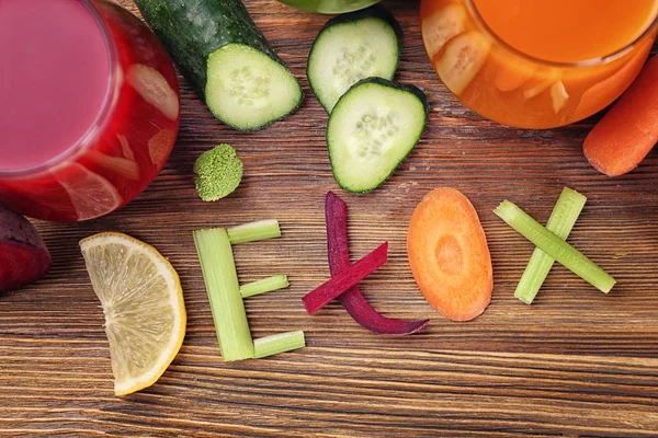 Malzemeler ve gözlük tablosundaki çeşitli taze meyve suları ile yapılmış Word Detoks