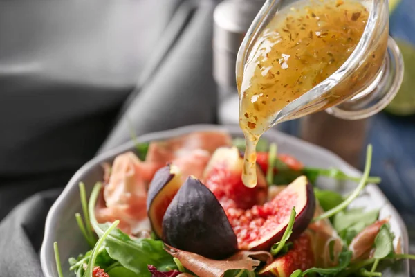 Додавання соусу до смачного свіжого салату в мисці, крупним планом — стокове фото