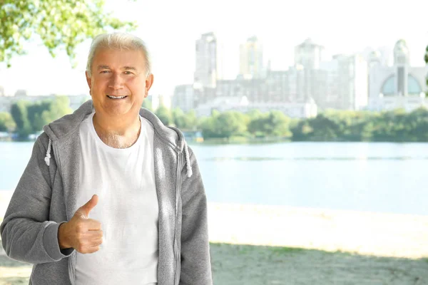 Homme mûr debout près de la rivière — Photo