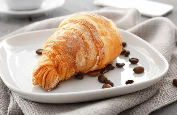 Plate with tasty croissant on table, closeup — Stock Photo, Image