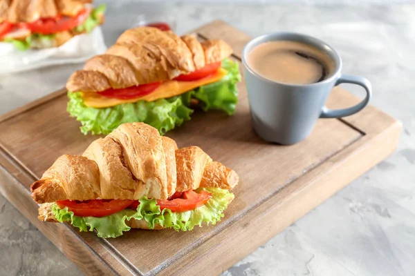 Tabla de madera con deliciosos sándwiches de croissant —  Fotos de Stock