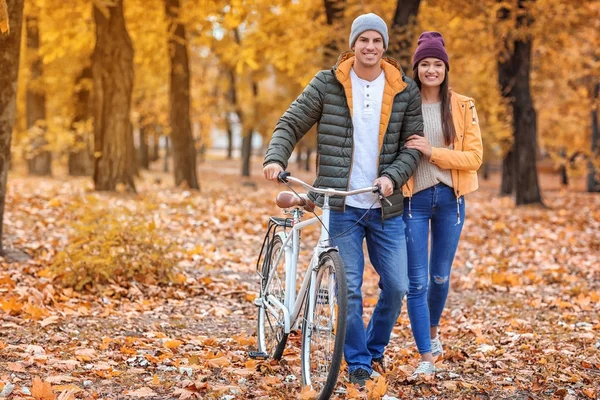 年轻夫妇步行与自行车通过秋天森林 — 图库照片