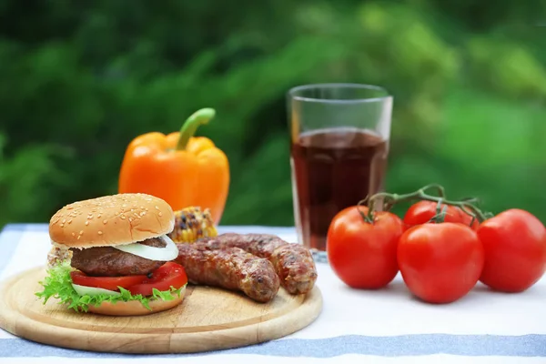 Wooden board with delicious hamburger — Stock Photo, Image