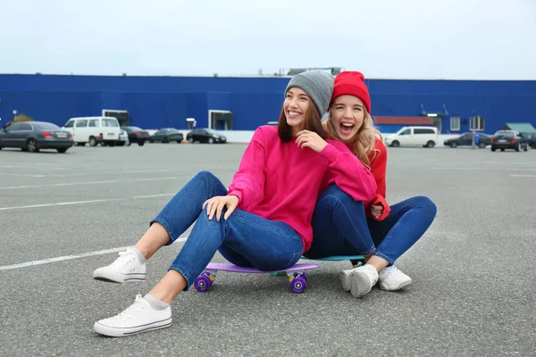 Δύο κορίτσια ευτυχισμένη hipster κάθεται για σκέιτμπορντ σε εξωτερικούς χώρους — Φωτογραφία Αρχείου