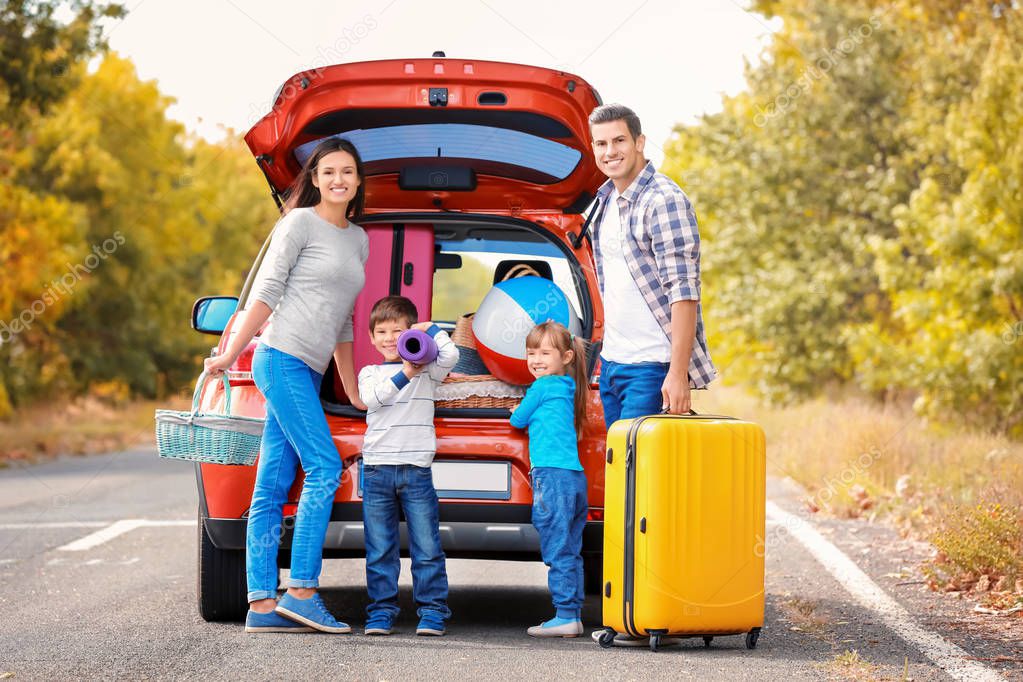 Happy family with luggage near car. Traveling concept