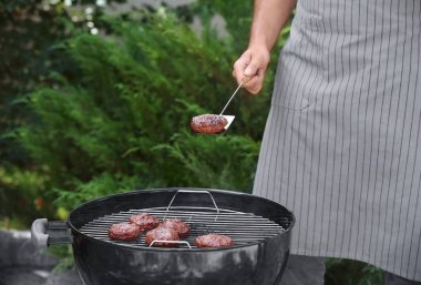 Adam açık havada mangal üzerinde leziz köftesi hazırlanıyor