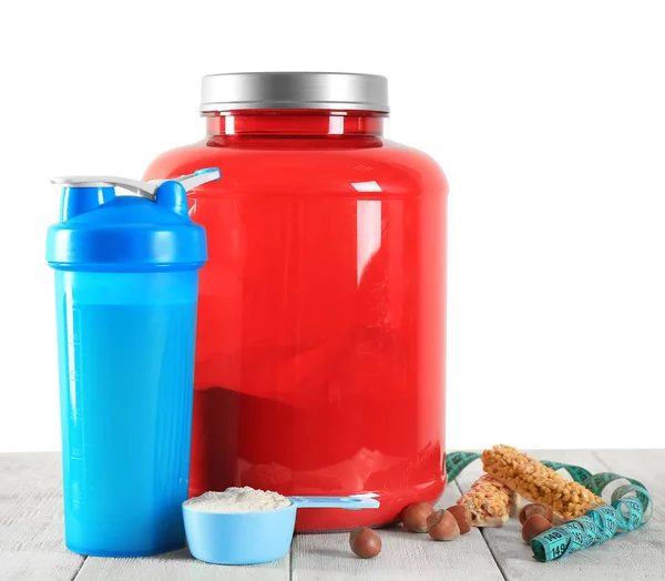 Protein shake in bottle, powder, bars and measuring tape on table — Stock Photo, Image