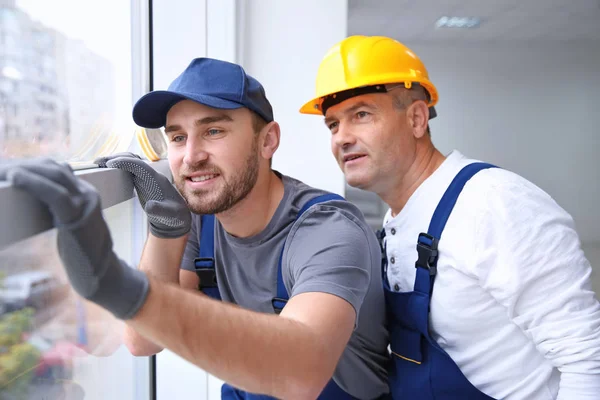 Trabajador de la construcción con aprendiz instalando ventana en casa —  Fotos de Stock